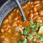 Salsa Pinto Beans in a bowl with chopped cilantro and lime