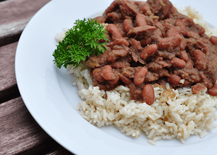 Louisiana Red Beans on top of rice on a white plate.