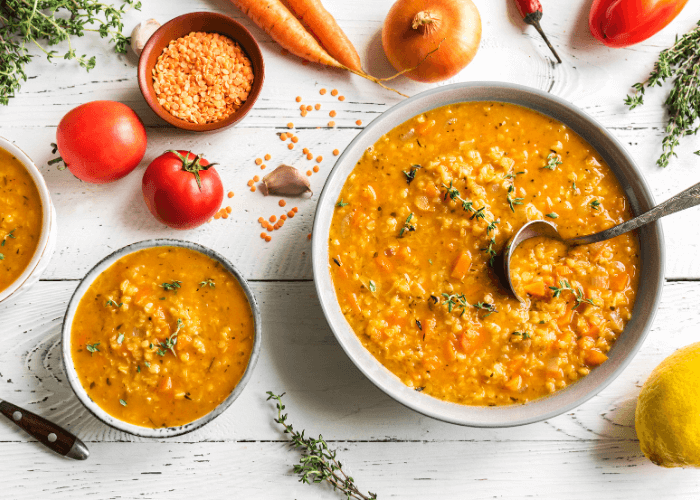 Lentil Soup in a white bowl with tomatoes , onions