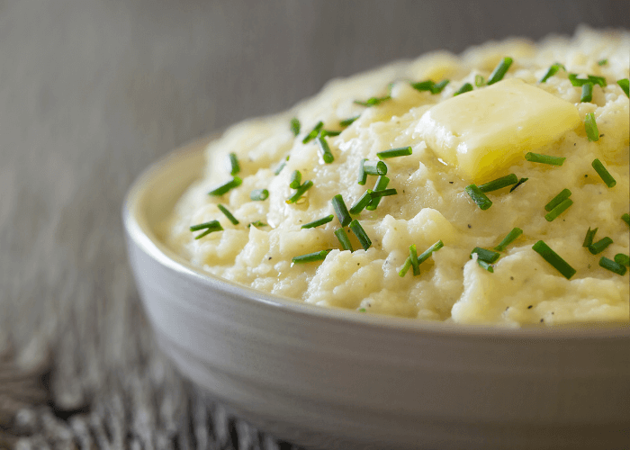 Creamy Mashed Parsnips with butter and chopped green onions in a bowl.