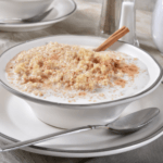 Cinnamon quinoa in a white bowl with a metal spoon.