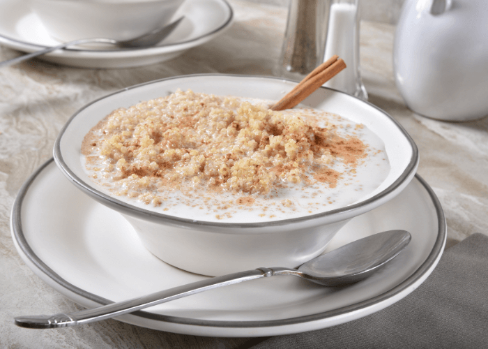 Cinnamon quinoa in a white bowl with a metal spoon.