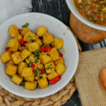 Tofu and red peppers in a white bowl