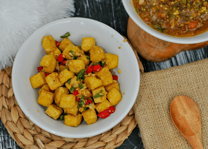 Tofu and red peppers in a white bowl