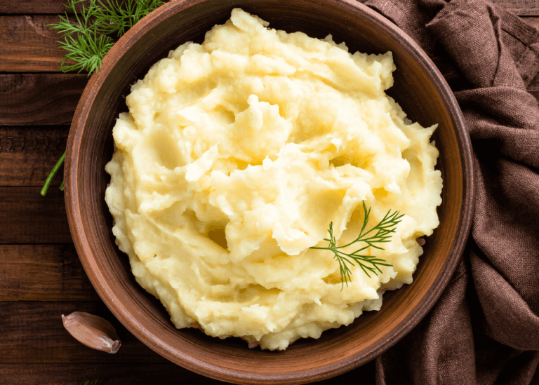 Mashed Potatoes in a wooden bowl with a dark background