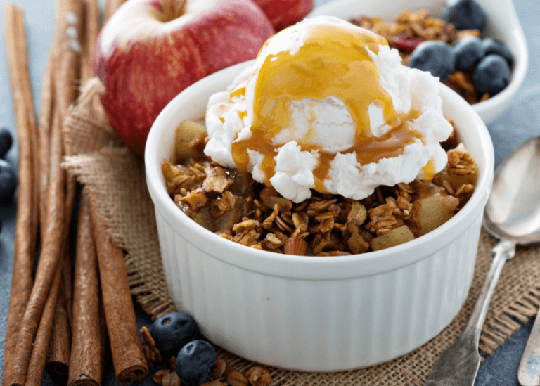 Microwave Fruit Crisp in a small white cup topped with ice cream and caramel