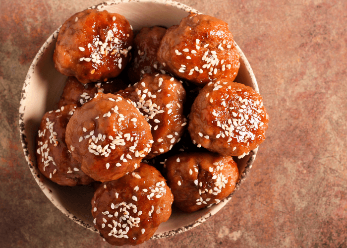 Teriyaki Meatballs in a small bowl topped with sesame seeds