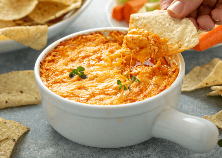 Chicken Buffalo Dip in a white bowl with a tortilla chip