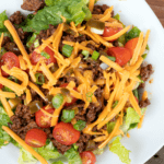 Taco Salad with shredded cheese, tomatoes. green onions