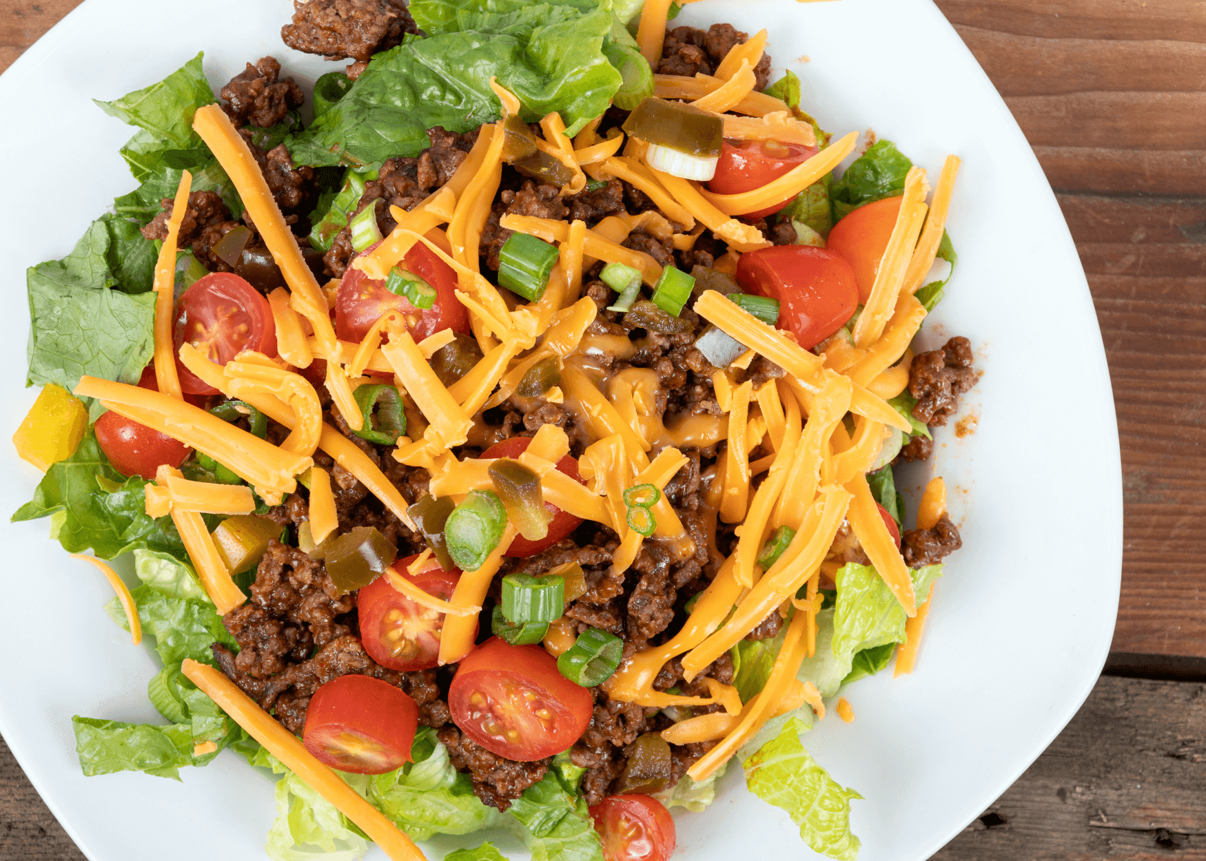 Taco Salad with shredded cheese, tomatoes. green onions