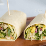 Pineapple Avocado Chicken Salad in a wrap cut in half