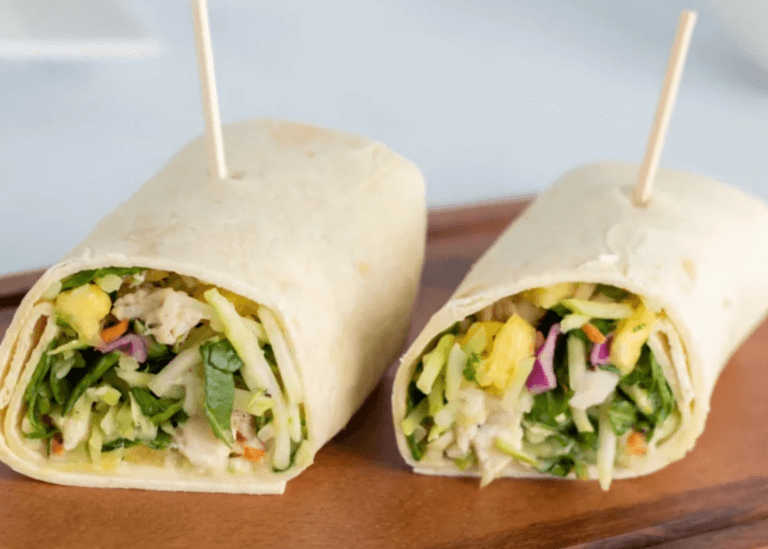 Pineapple Avocado Chicken Salad in a wrap cut in half