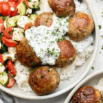 Greek Turkey Meatballs with Tzatziki, cucumbers, tomatoes, feta in a white bowl