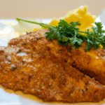 Crispy Parmesan Baked Fish topped with fresh herbs