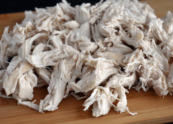 Slow Cooker Shredded Chicken on a wood cutting board