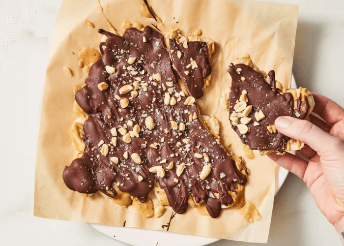 Peanut Butter Banana Bark with chopped peanuts on parchment paper
