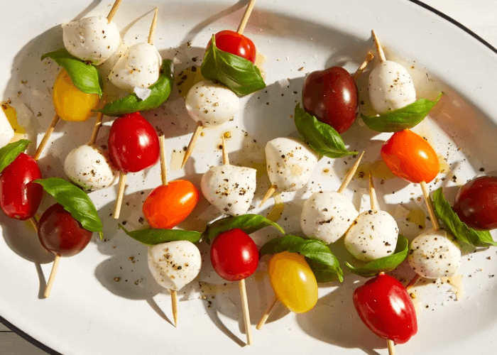 Caprese Skewers with mozzarella balls, basil leaves, and cherry tomatoes