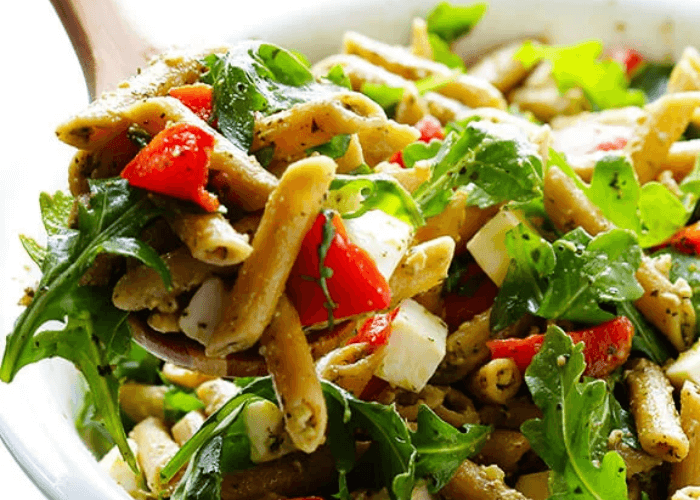 Pesto Pasta Salad with whole wheat pasta, roasted red peppers, mozzarella cheese, and arugula