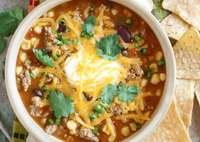 Turkey Taco Soup topped with shredded cheese and sour cream