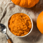 Easy Pumpkin Puree in a white bowl next to a pumpkin