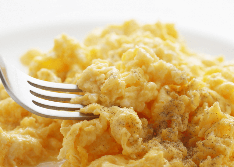 Fluffy scrambled eggs with a fork