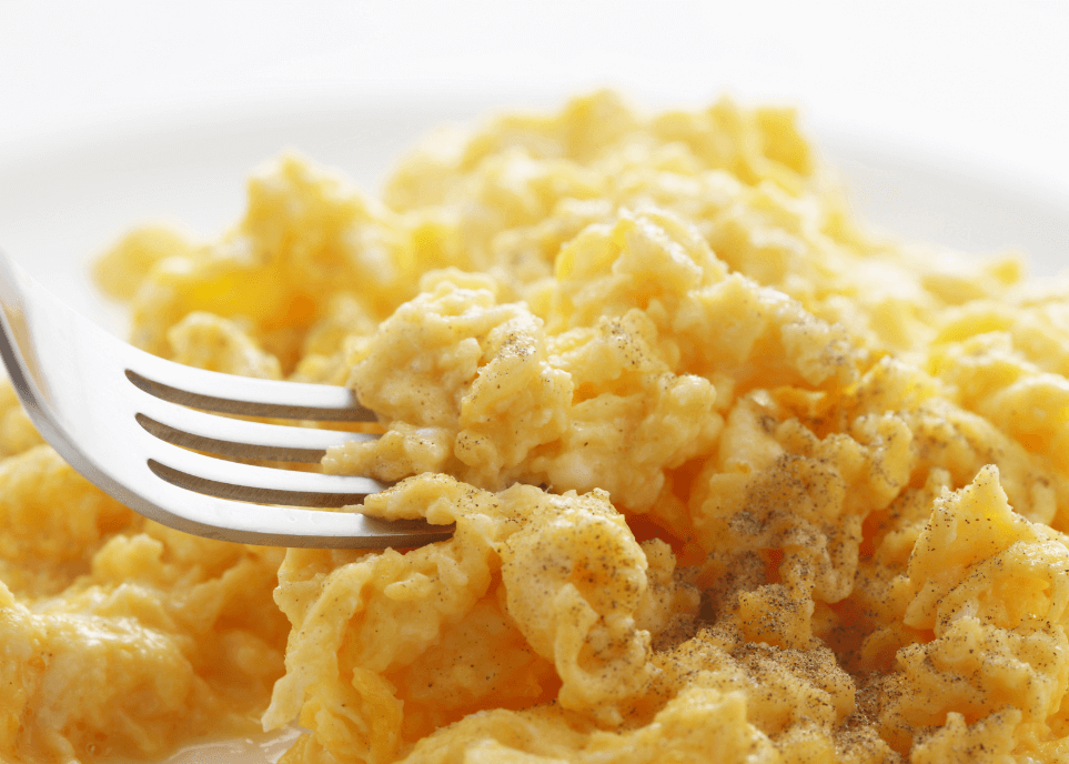 Fluffy scrambled eggs with a fork