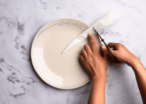 Paper plate on a marble countertop with a plate and parchment paper