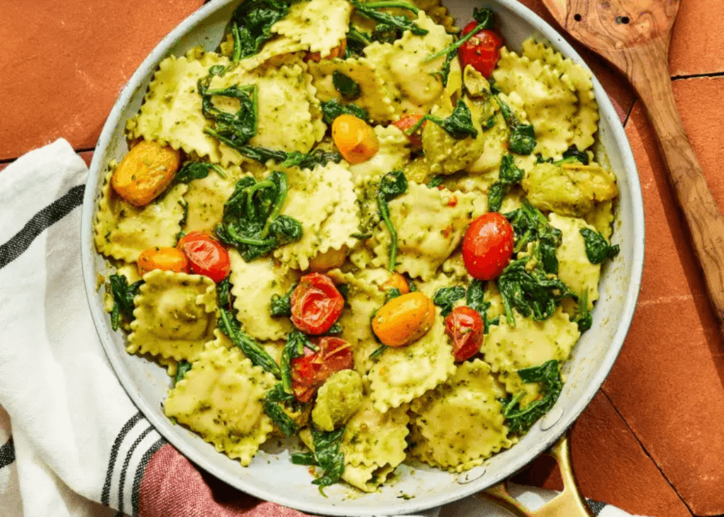 Pesto Ravioli with Spinach & Tomatoes in a skillet