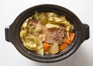 cabbage, corned beef, carrots, and liquid in a crockpot